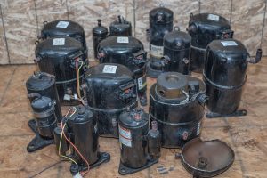 Several bad central air coditioner compressors next to each other, scrap metal