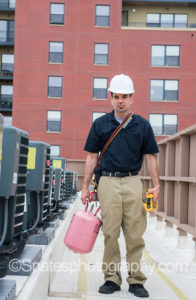 Hvac Training - Technician with air conditioning repair tools on rooftop