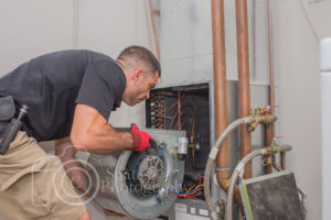 hvac technician installing blower motor in a commercial heat pump