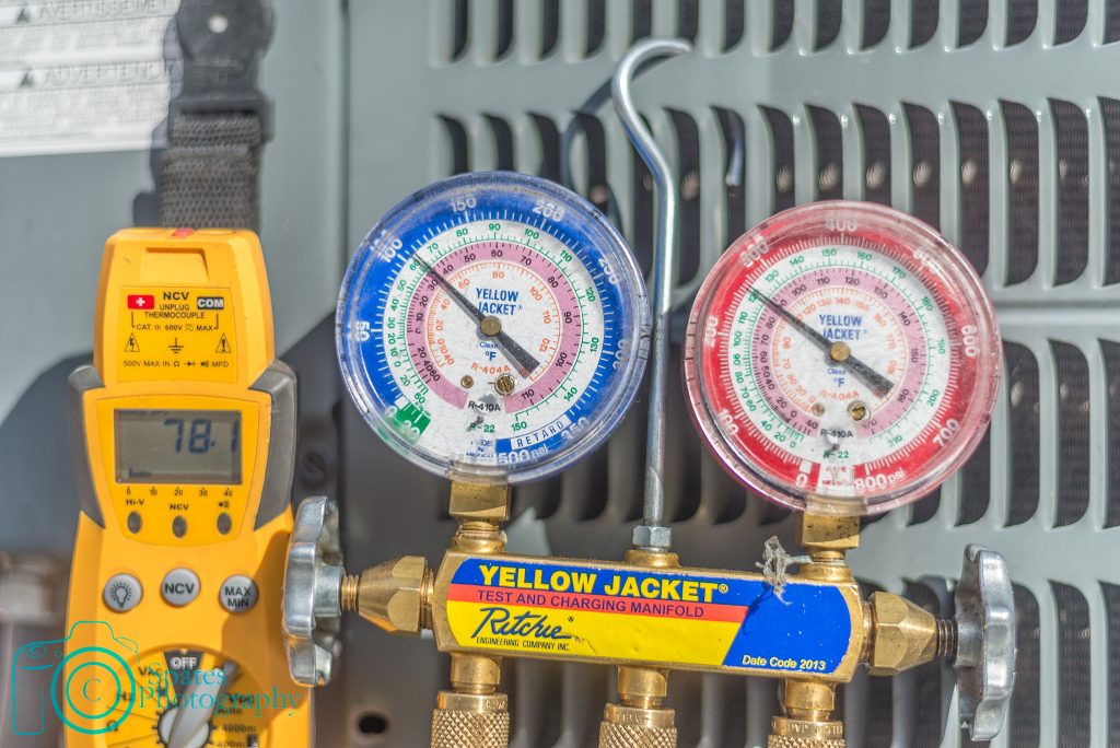 Refrigerant gauges displaying pressure, multi-meter displaying temperature to calculate air conditioning subcooling