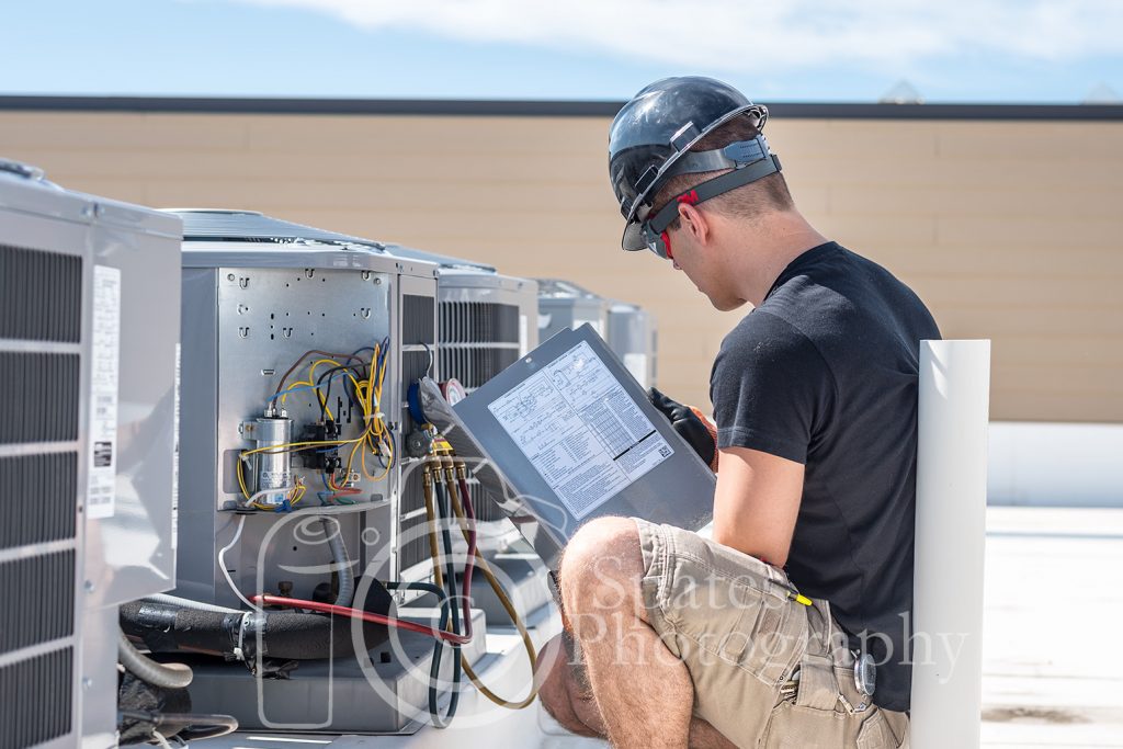 HVAC service technician reading the back of a condenser panel to get the target subcooling charge on a carrier air conditioner