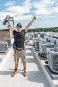 HVAC tech raising his hands up volunteering 